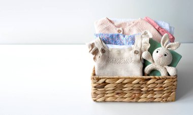 Bebek kıyafetleri sepette boş fotokopi odasında katlanmış yeni doğan kıyafetleri ve oyuncaklar, küçük çocuklar, renkli kadın giysileri.