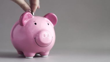 Boş gri arka plan üzerine kumbara, pembe domuzcuk, el yapımı paralar, para tasarrufu, yatırım. Banka ve finansal konsept..