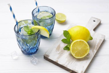 Beyaz ahşap masada bardakta limonlu buzlu su. Ev yapımı Leon. Taze yaz içeceği, narenciye. Hiç kimse..