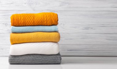 Bir yığın katlanmış süveter, renkli sonbahar örgü yığını. Yünlü giysiler yığını. Sarı örgü elbise. Örülmüş kaşmir çamaşırhane boş kopya alanı.