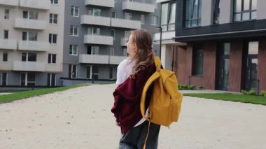 Beyaz bir kız çocuğu, kompleks bahçeyle yolda yürüyor. Okul kızı evine gidiyor. Okula geri dön..