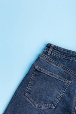 Arkadan mavi arka planda mavi kot pantolon. Arka cebinde kot pantolon. Üst Manzara. Denim bezi. Model