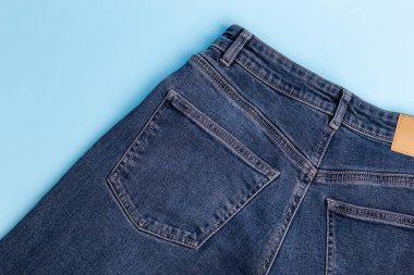 Arkadan mavi arka planda mavi kot pantolon. Arka cebinde kot pantolon. Üst Manzara. Denim bezi. Model