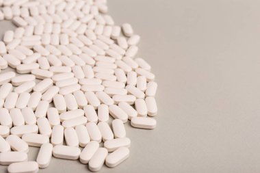 Arka planda beyaz haplar var. İlaçlar düzdü. Büyük miktarda beyaz tabletlerin arka planı