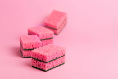 Pembe arka planda bulaşık yıkamak için pembe mutfak süngeri. Ev ödevi. Ev işleri işte. Bulaşık yıkama.