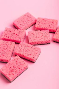 Pembe arka planda bulaşık yıkamak için pembe mutfak süngerleri. Ev ödevi. Ev işleri işte. Bulaşık yıkama.