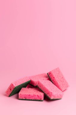 Pembe arka planda bulaşık yıkamak için pembe mutfak süngeri. Ev ödevi. Ev işleri işte. Bulaşık yıkama.