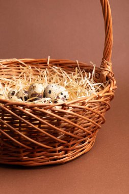 Kahverengi arka planda sepetteki bıldırcın yumurtaları. Bıldırcın yumurtalı güzel bir kompozisyon..