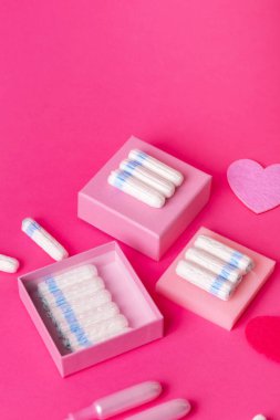 Pembe arka planda çok sayıda regl hijyeni tamponu ve güzel bir kompozisyon. Adet döneminde kadınlar için yumuşak pamuk emici adet tamponları. Kadın hijyeni.. 