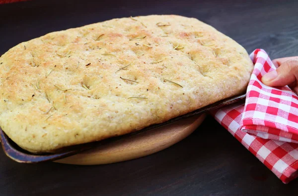 Hand Placing Pan Freshly Baked Herbed Focaccia Bread Breadboard — Stock Photo, Image