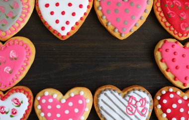 Gorgeous frames of heart shaped with adorable pattern cookies on black background
