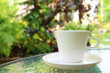 Bahçe masasındaki beyaz kahve fincanını kapat.