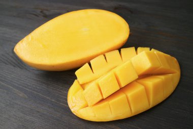 Ağız sulandıran taze olgun mango kesimi ve çapraz kesim Kara Tahta Masa 'da izole edildi.