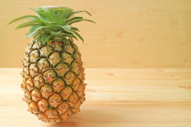 Tahta zeminde izole edilmiş taze olgun ananas.
