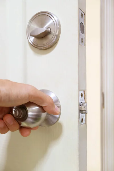 Stock image Hand holding steel doorknob for closing the door