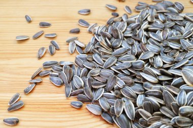 Tahta masaya saçılmış çiğ ayçekirdeği yığını.