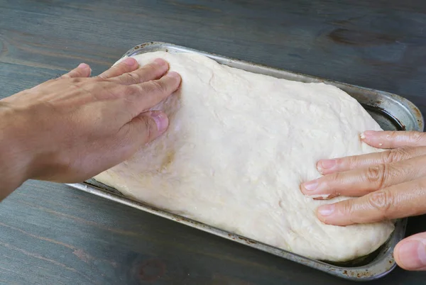 手はピザを焼くためのパンに上昇生地を伸ばし — ストック写真