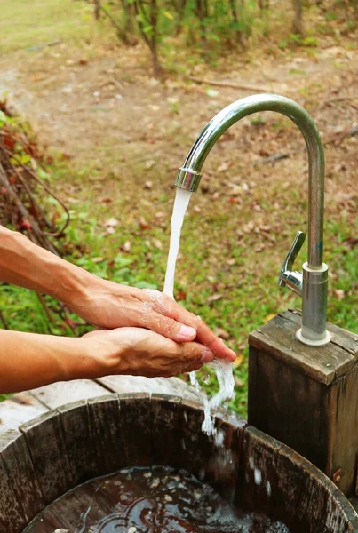 Bahçedeki Musluktan Akan Suyun Altında Bir Adamın Elleri — Stok fotoğraf