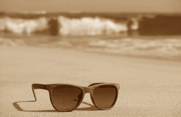 Sepia Beeld Van Zonnebril Het Zandstrand Met Spetterende Golven Achtergrond — Stockfoto