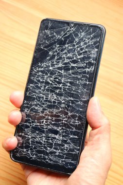 Bozuk ekranlı bir telefonu tutarken