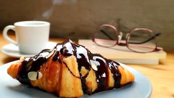 Záběry Croissant Vlhkou Čokoládovou Omáčkou Šálek Horké Kávy Pozadí — Stock video