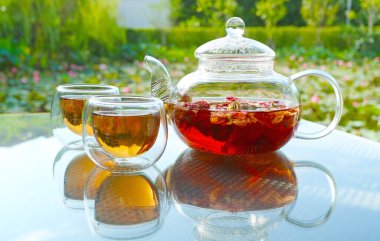 Bahçe masasında sıcak kokulu çay kadehleri servis edilir.