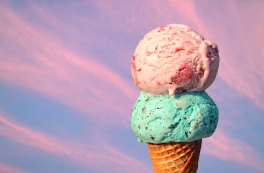 Pembe gökyüzü arka planında iki kepçe erimiş dondurma.