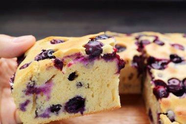 Yaban mersinli kekin ağız sulandıran bir dilimini seçerken yakın plan.