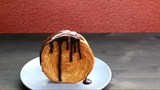 一个令人垂涎三尺的最高羊角面包或纽约卷与流动的巧克力酱的镜头 — 图库视频影像