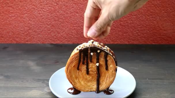 Lezzetli Bir Çikolatalı Üstün Kruvasan Üzerine Doğranmış Fındık Serpiştirme Görüntüsü — Stok video