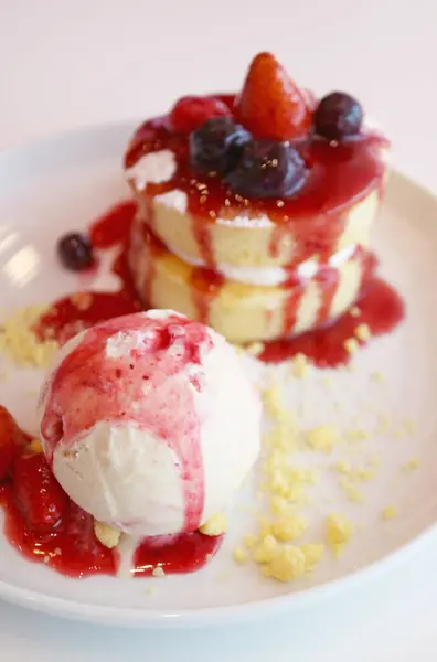 Vanilla ice cream and chiffon cake with strawberry and blueberry sauce