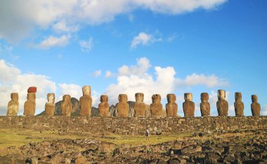 Ahu Tongariki 'deki devasa Moai heykellerinin arkasında fotoğraf çeken bir ziyaretçi var. Paskalya Adası, Şili, Güney Amerika.