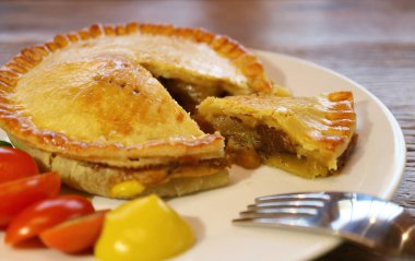 Tahta Masa üzerinde servis edilen nefis bir tabak altın sarısı etli börek.