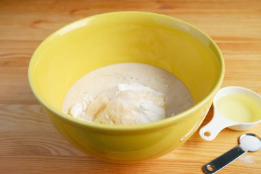 Ekmek hamuru yapmak için bir kase unu mayayla karıştırıyorum.