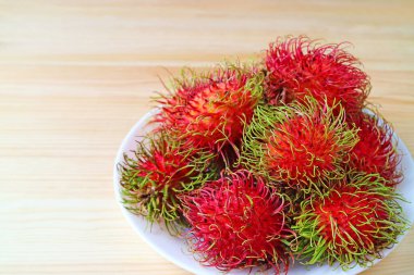 Parlak Kırmızı Renkli Tabak Olgun Rambutan Meyveleri Tahta Masada İzole Edildi