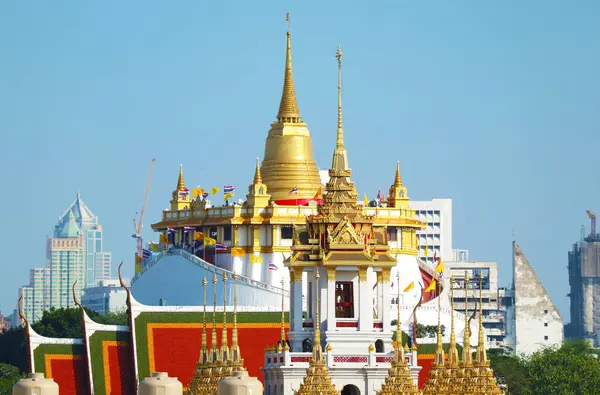 stock image Stunning Phu Khao Thong (Golden Mount) of Wat Saket Temple with the Spires of Loha Prasat (Iron Castle) of Wat Ratchanatdaram Temple in Foreground, Bangkok City Skyline, Thailand