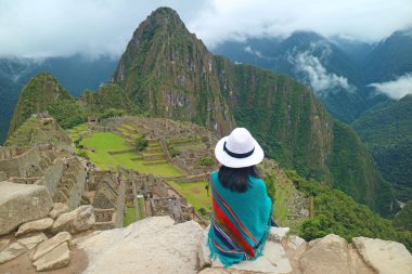 Machu Picchu 'nun İnka harabelerinden etkilenen Uçurumda Oturan Ziyaretçi, Cusco Bölgesindeki UNESCO Dünya Mirası Bölgesi, Urubamba Eyaleti, Peru, Güney Amerika