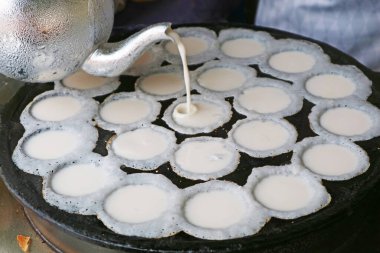 Kanom krok ya da Tayland hindistancevizi sütü krep hamuru Pan 'ın deliğine dökülüyor.