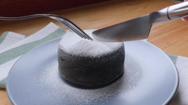 Taze pişmiş ağız sulandıran erimiş çikolatalı pastanın kesilmesi.