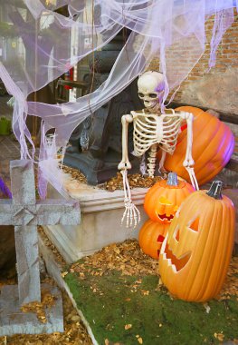 Halloween Decoration with Pile of Jack-O'-lantern Pumpkins and Skeleton in the Garden clipart