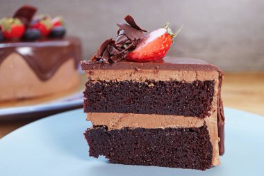 Taze çilek ve yaban mersinli dilimli siyah çikolatalı kek.