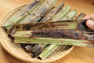 Lezzetli Khanom Jaak, Nipa palmiye yaprağına sarılmış kavrulmuş siyah pirinç unlu kekten yapılan popüler Tayland tatlıları.