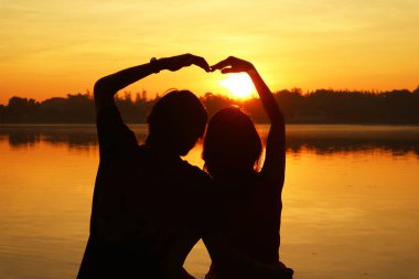 Parlak Güneş 'e Kalp İşareti Yapan Bir Çiftin Silueti