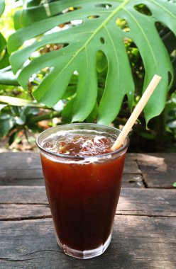 Bahçe Tahta Masası 'na izole edilmiş bir bardak soğuk buzlu sade kahve.