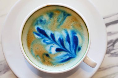 Ağız sulandıran kapuçino kahve ile mavi kelebek latte sanatı.