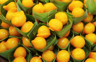 Rows of Med Kanoon,  Thai Traditional Dessert Made of Sweetened Beans Paste Dipped in Beaten Egg Yolks and Cooked in Syrup clipart