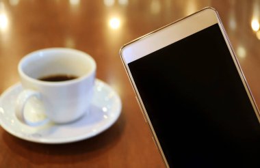 Arkaplanda Bulanık Siyah Kahve ile Boş Ekran Cep Telefonunun Kapanışı