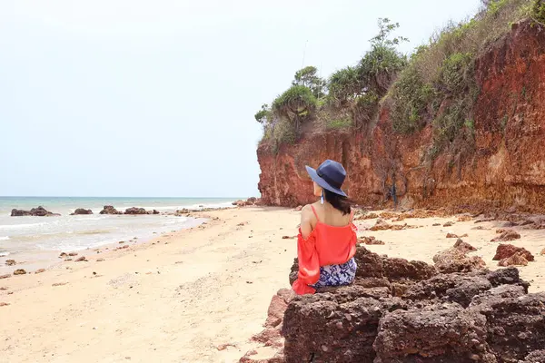 Pha Daeng Sahili 'nin kırmızı renkli kayasında oturan bir kadın. Milyonlarca yıldır Tayland' ın Uygulamalı Khiri Khiri Khiri Bölgesi 'nde Demir Yatırım' ın Kızıl Uçurumu.