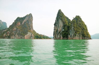 Güney Tayland 'da, Surat Thani Eyaleti, Khao Sok Ulusal Parkı' ndaki Ratchaprapa Barajı veya Cheow Lan Gölü 'nün yeşil berrak sularıyla muhteşem bir manzara.