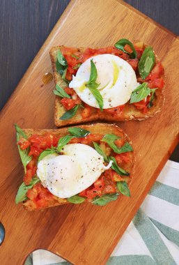Taze domates ve fesleğenli kepekli tost üzerine taze pişmiş yumurta.